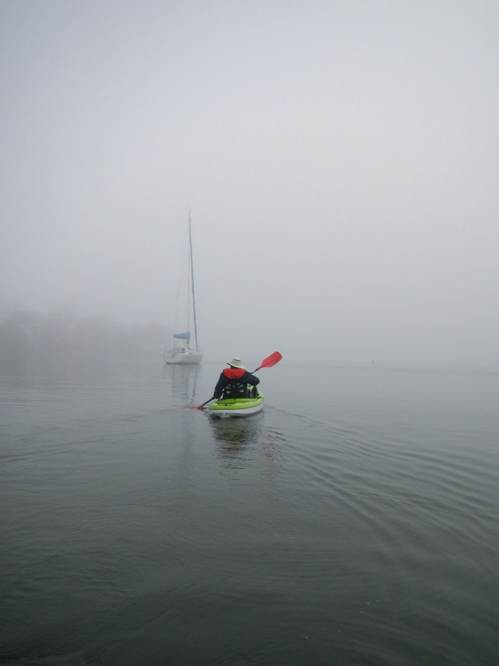 a person paddling a kayak on a foggy day