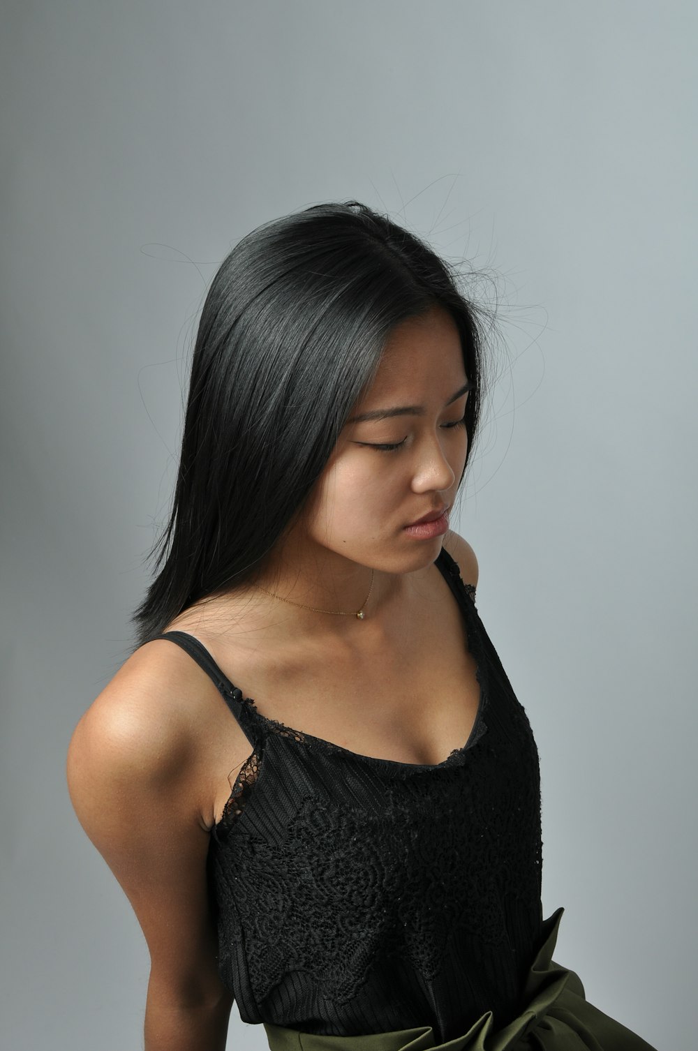 a woman with long black hair wearing a black top
