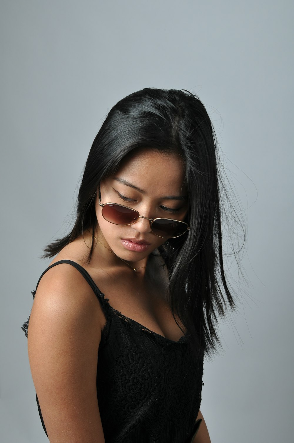 Una mujer con un vestido negro con gafas de sol en la cabeza