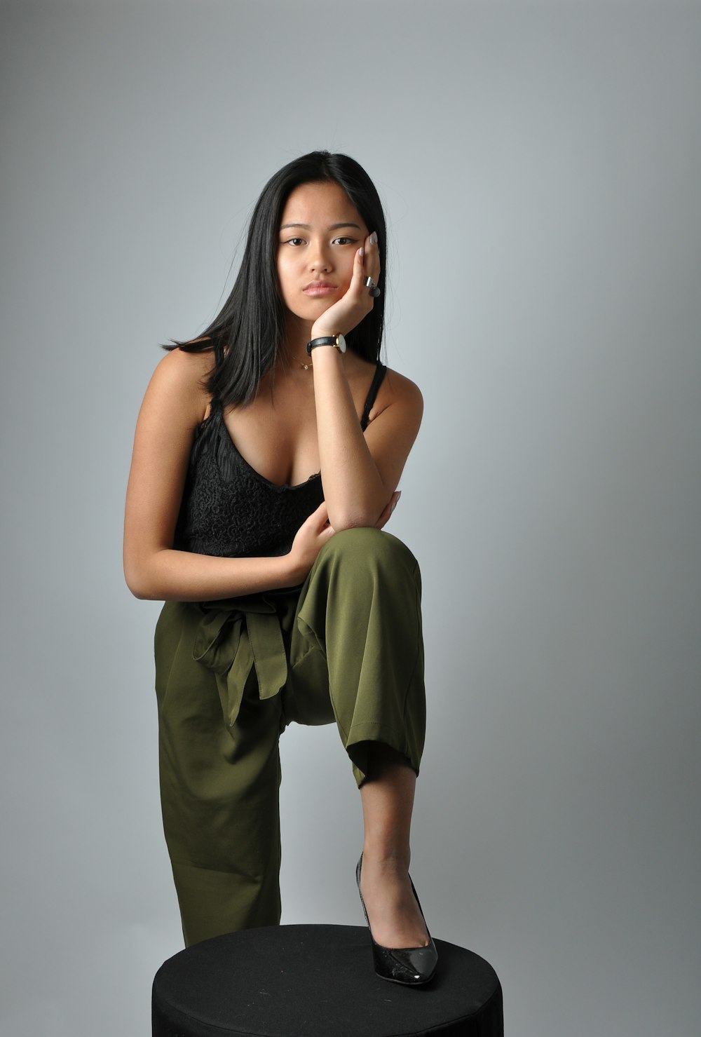 a woman sitting on top of a black stool