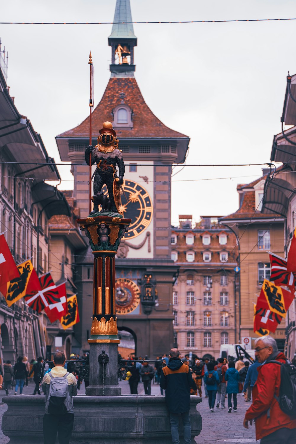 a group of people standing around a clock tower