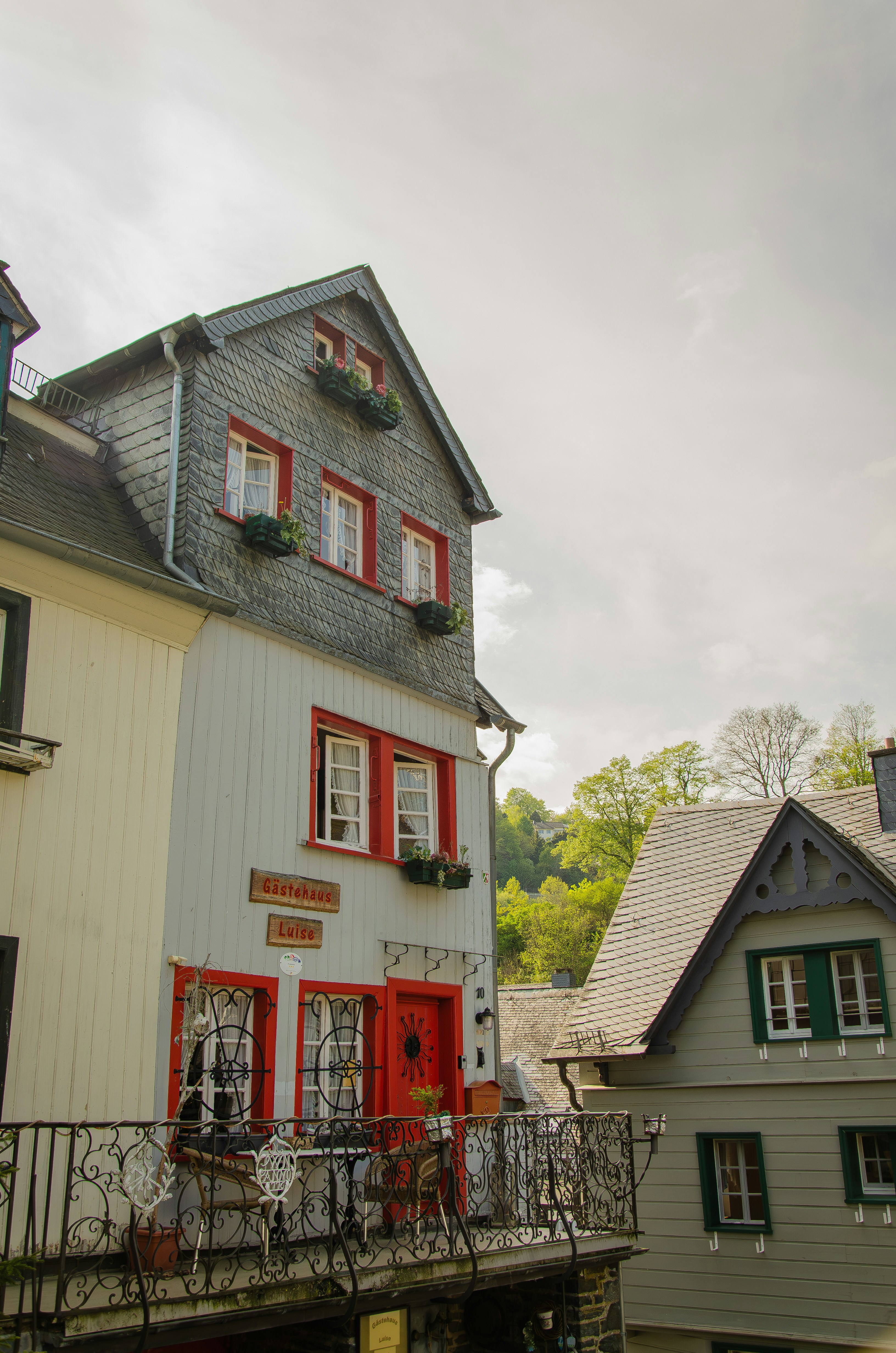 a house with red shutters and a balcony