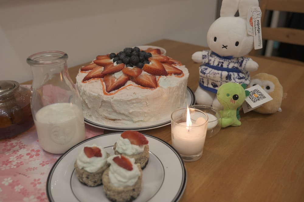 a table topped with a cake covered in strawberries