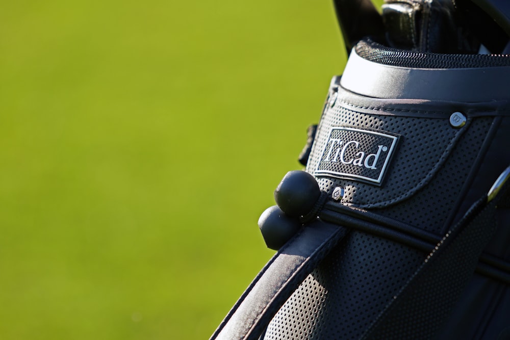 a close up of a golf bag on a green field