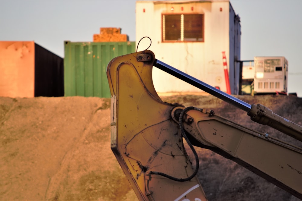 the back end of a bulldozer with a building in the background