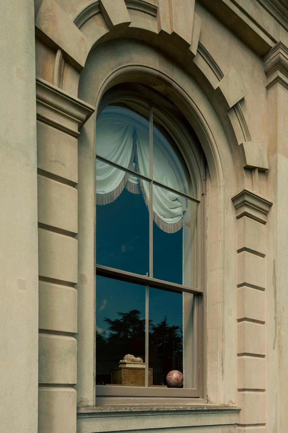 a window with a curtain and a suitcase in it