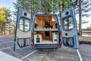 Close-up of a sleek portable refrigerator installed inside a camper van, with soft ambient lighting highlighting its modern design.