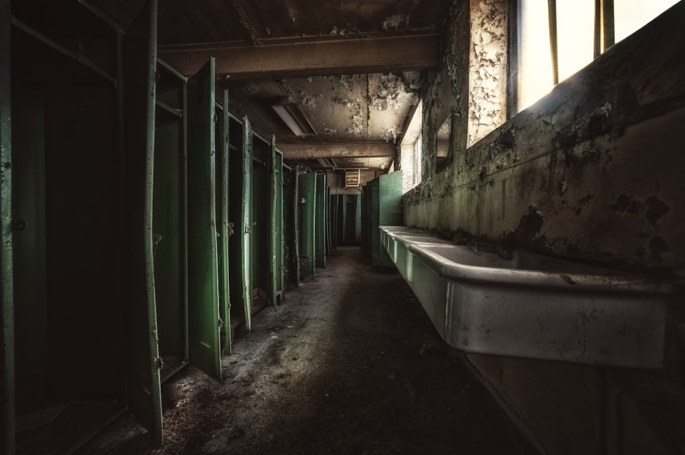 a row of green lockers in a run down building
