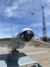Close-up of a sleek lidar sensor scanning an urban environment.