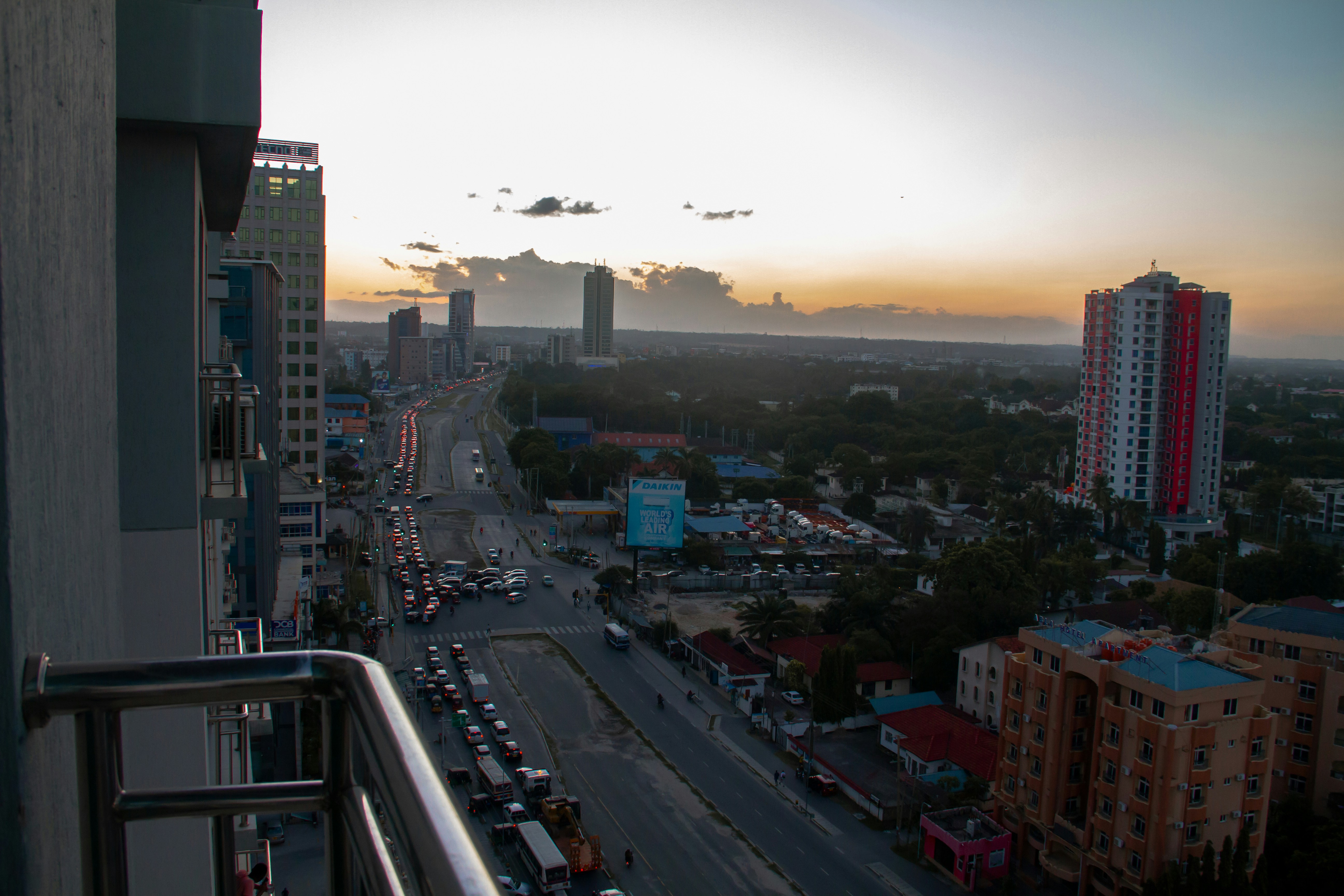 a city street filled with lots of traffic next to tall buildings
