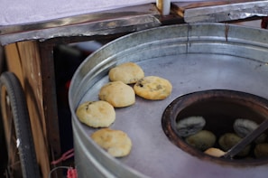Fresh naan bread coming out of the tandoor oven with golden brown spots