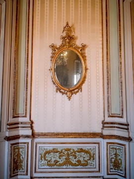 An ornate wall mirror surrounded by elegant decor elements.
