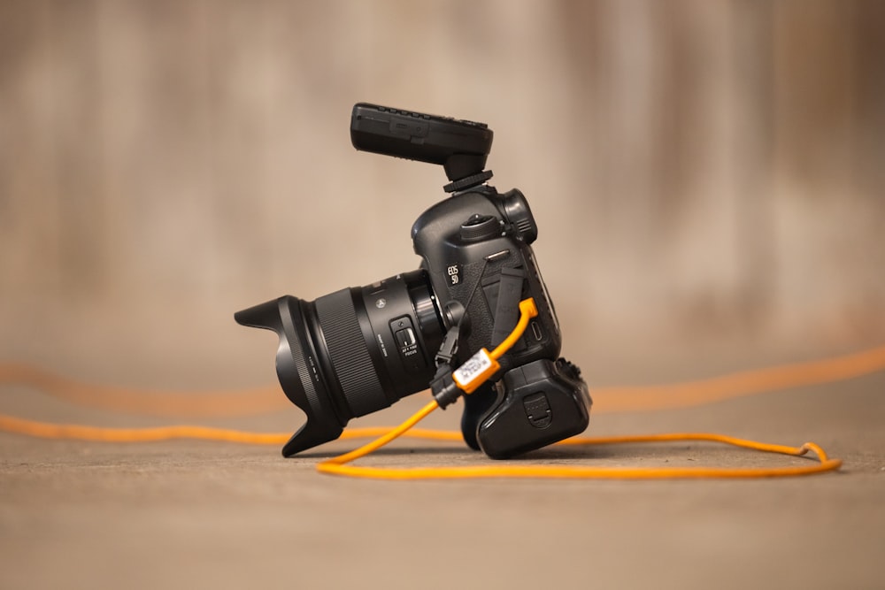 a camera with a yellow cord attached to it