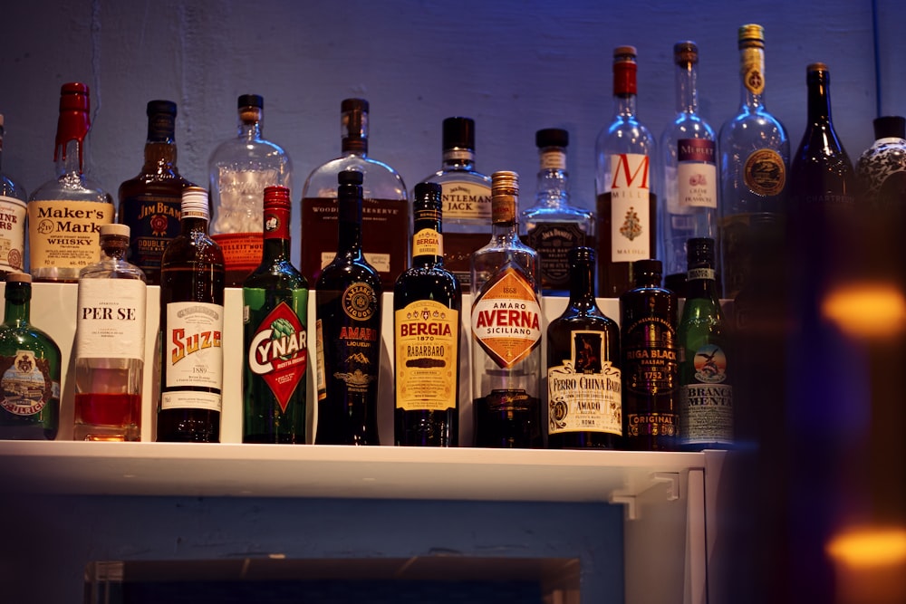 Un tas de bouteilles d'alcool sont alignées sur une étagère photo – Photo  De l'alcool Gratuite sur Unsplash