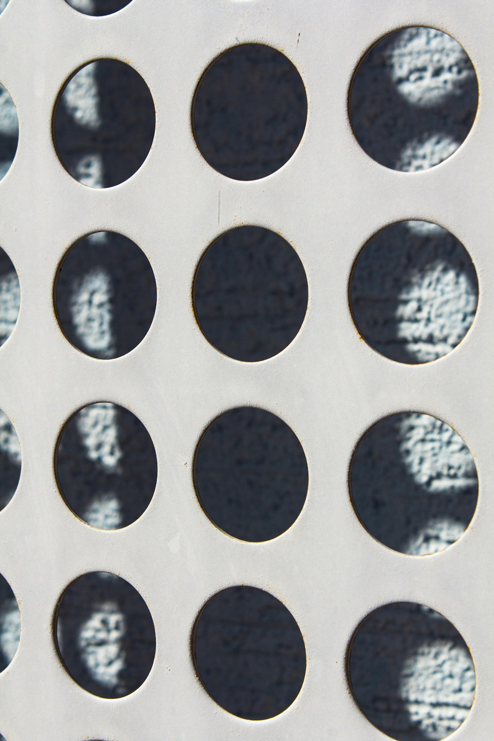 a close up of a metal grate with circles on it