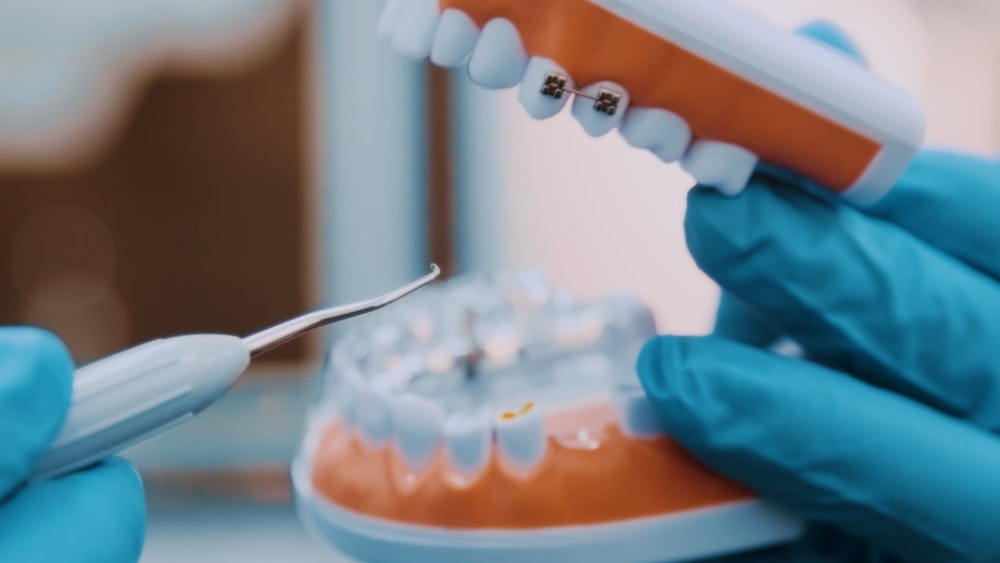 a person in blue gloves holding a toothbrush