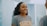A woman smiling confidently while looking in a mirror, reflecting self-assurance.