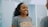 A woman smiling confidently while looking in a mirror, reflecting self-assurance.