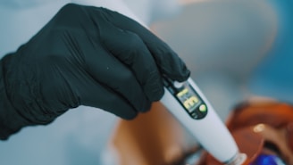 Close-up of a hand placing a bid on a digital device showing auction items.