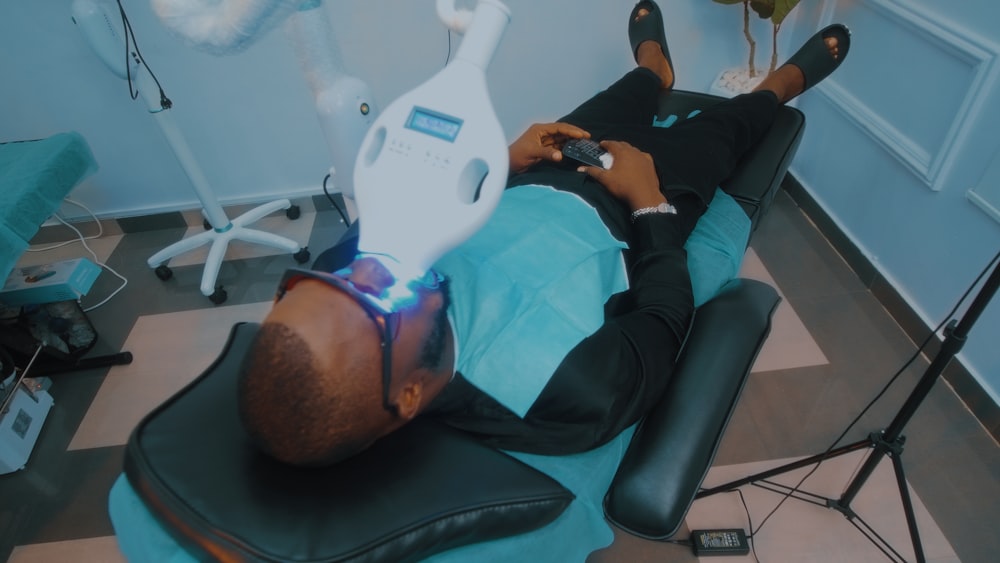 a man laying on a chair in a dentist's office