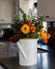 A bright, ergonomic watering can placed among blooming flowers.