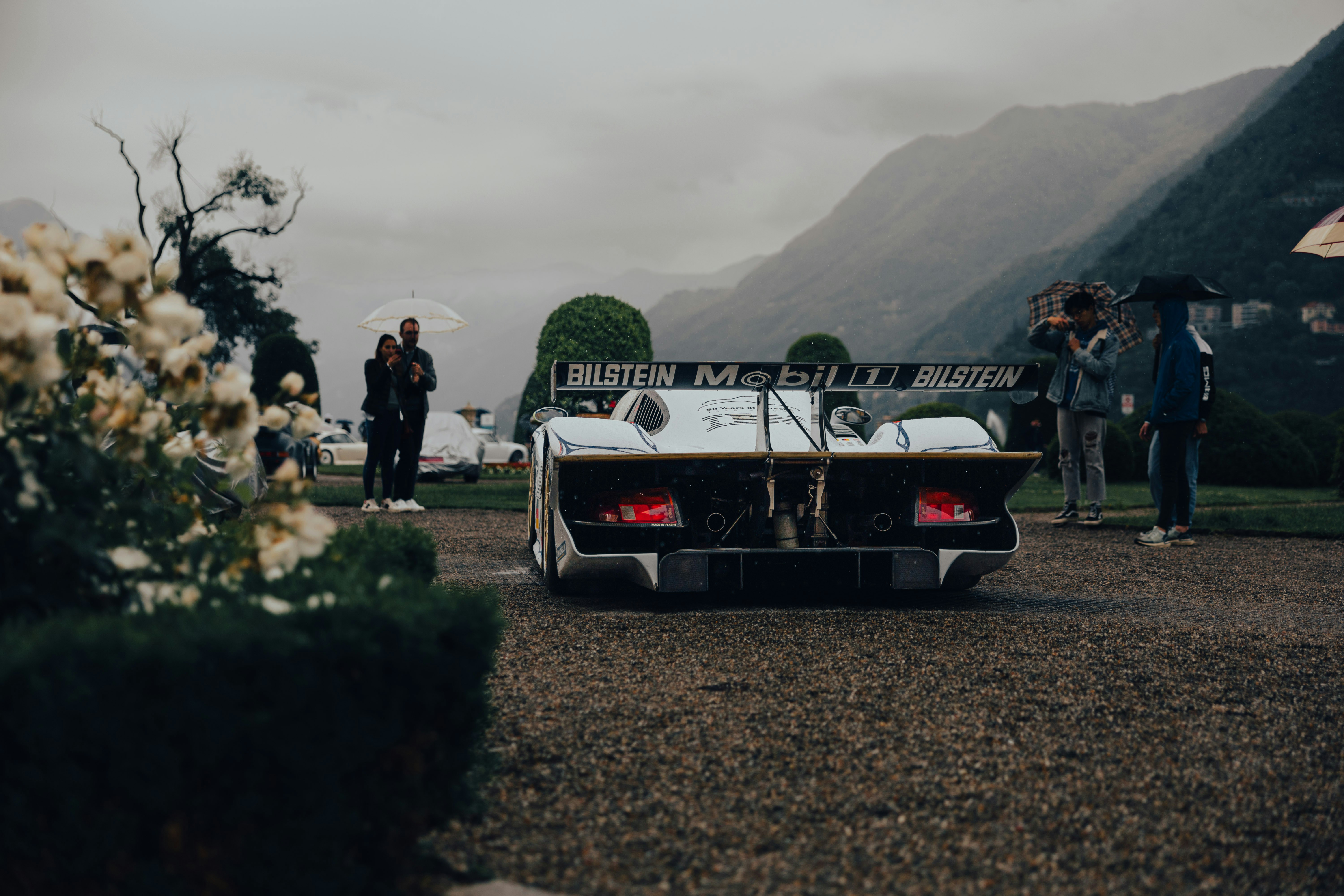 a car parked on a gravel road next to a group of people
