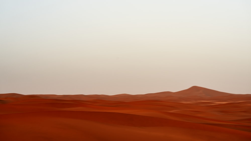 a lone airplane flying over a desert landscape