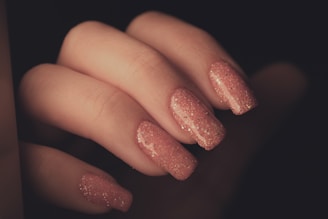 a woman's hand with a pink manicure