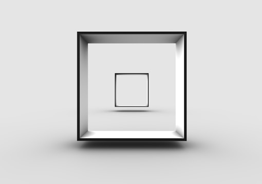 A minimalist 3D rendering of a cube-shaped frame suspended in a stark gray environment. Within the larger frame, a smaller, identical frame is positioned centrally, creating a sense of depth and recursion.
