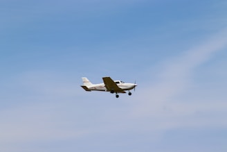 a small plane flying through a blue sky