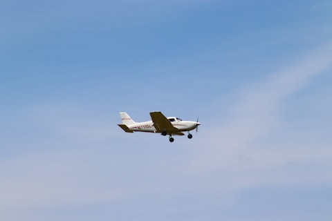 a small plane flying through a blue sky