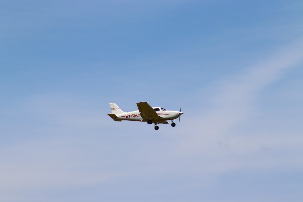 a small plane flying through a blue sky