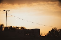Evening shot of the trailer park’s iconic corrugated metal fences decorated with colorful string lights.