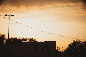 Evening shot of the trailer park’s iconic corrugated metal fences decorated with colorful string lights.