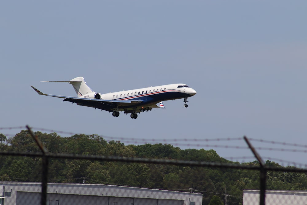 a plane is flying low over a fence