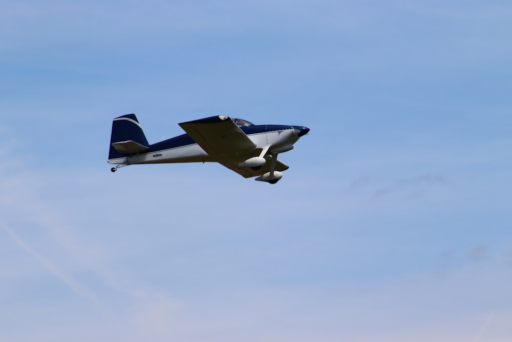 a small airplane flying through a blue sky