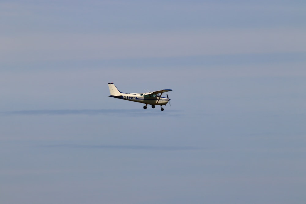 a small airplane flying through a blue sky