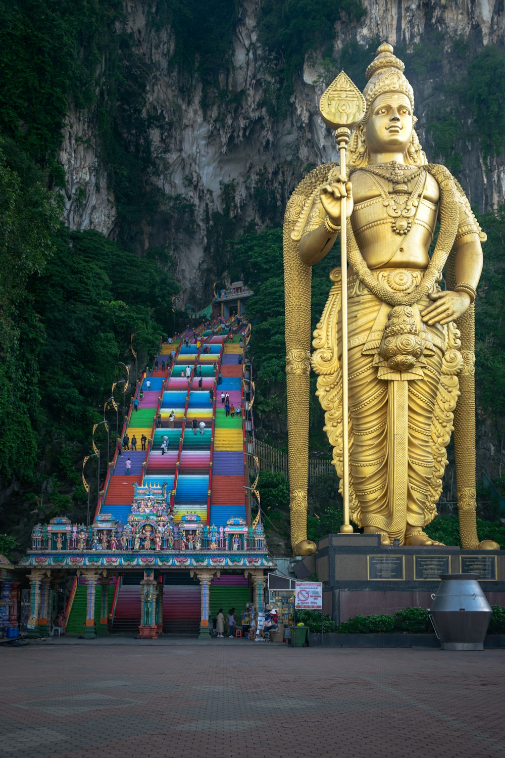 a large golden statue of a god in front of a mountain