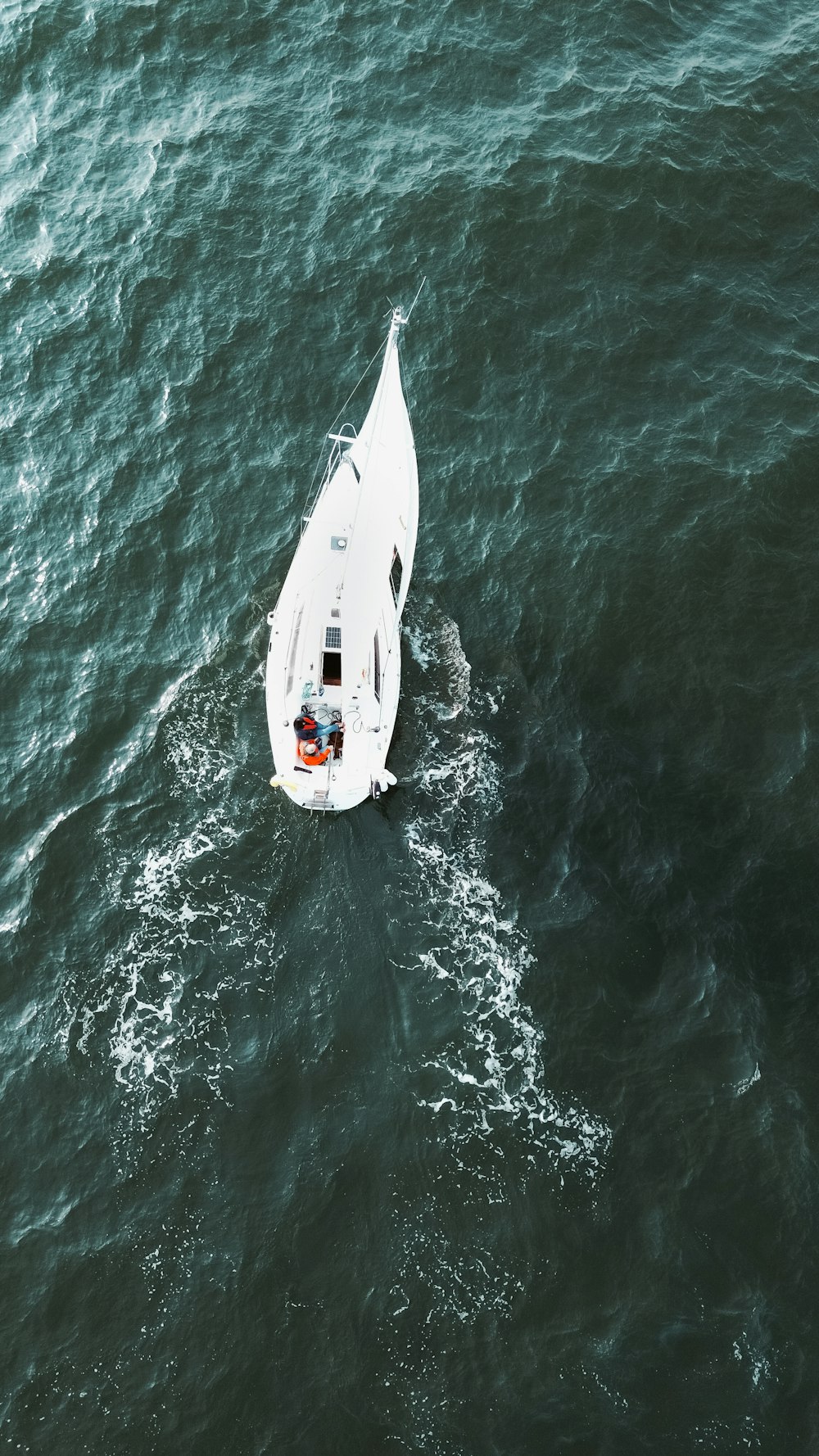 a small white boat floating on top of a body of water