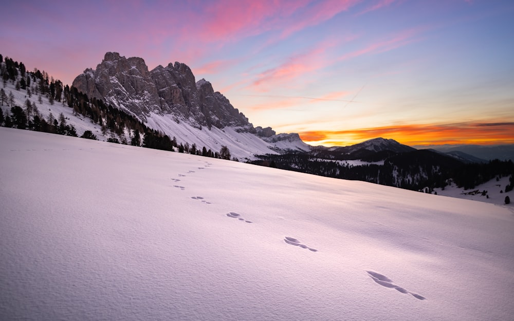 a snow covered mountain with footprints in the snow