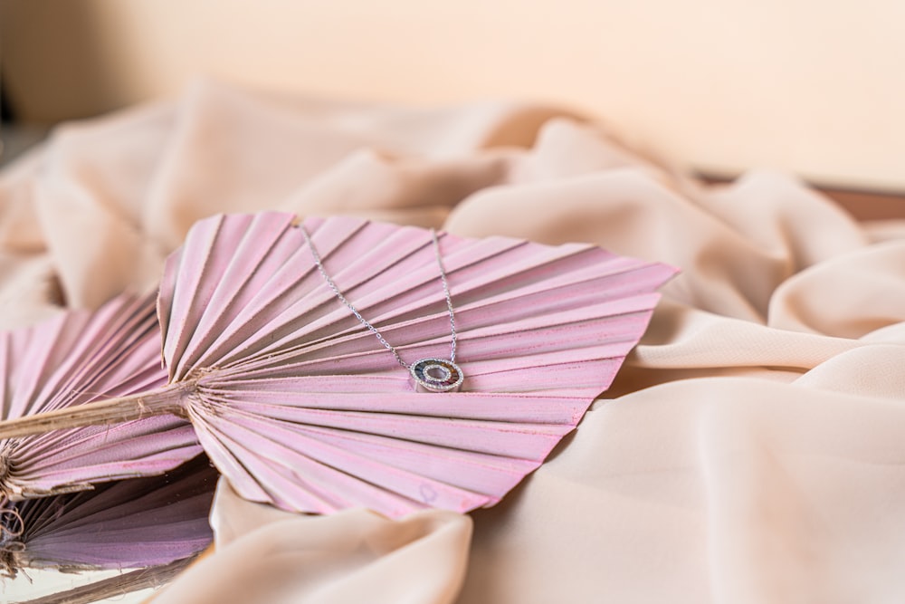 a pink fan laying on top of a bed