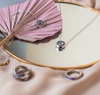 a pink fan sitting on top of a table next to a mirror