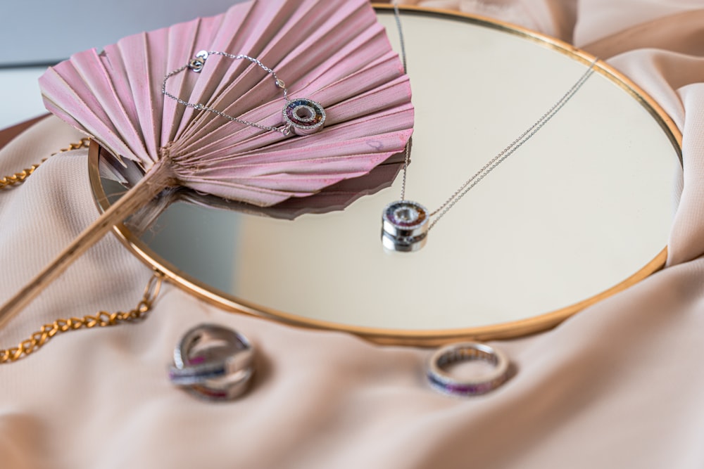 a pink fan sitting on top of a table next to a mirror