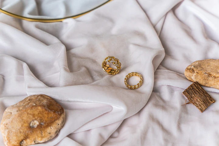 Gold hoop earrings arranged on white linen