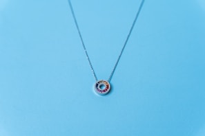 A stunning necklace with colorful gemstones laid out on a silk fabric background.