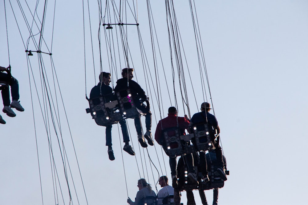 a group of people riding on top of a zip line