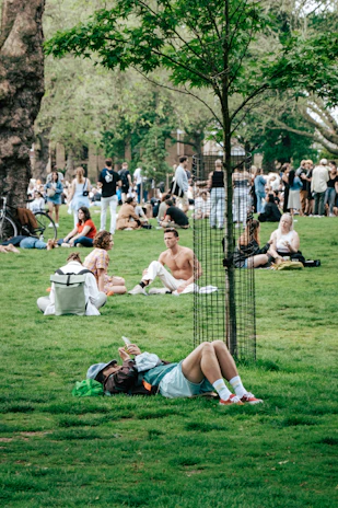 A diverse group of people reading news on their smartphones in a park.