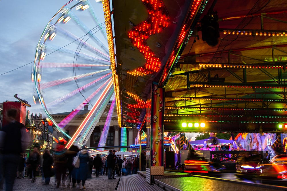 a carnival with a ferris wheel in the background