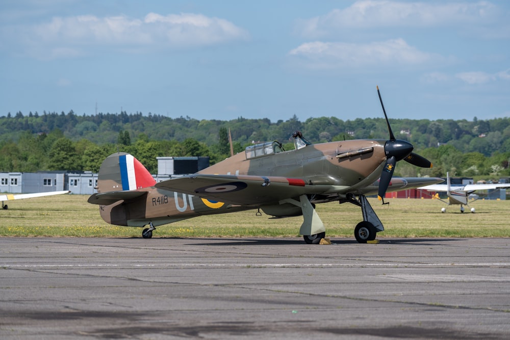 ein kleines Flugzeug, das auf dem Rollfeld eines Flughafens sitzt