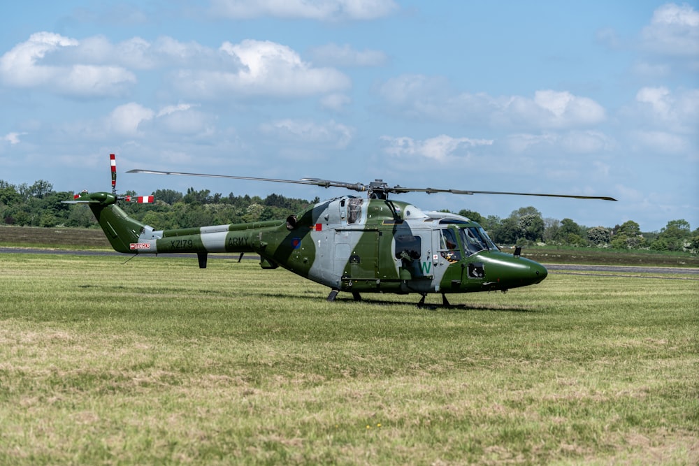um helicóptero sentado em cima de um campo coberto de grama